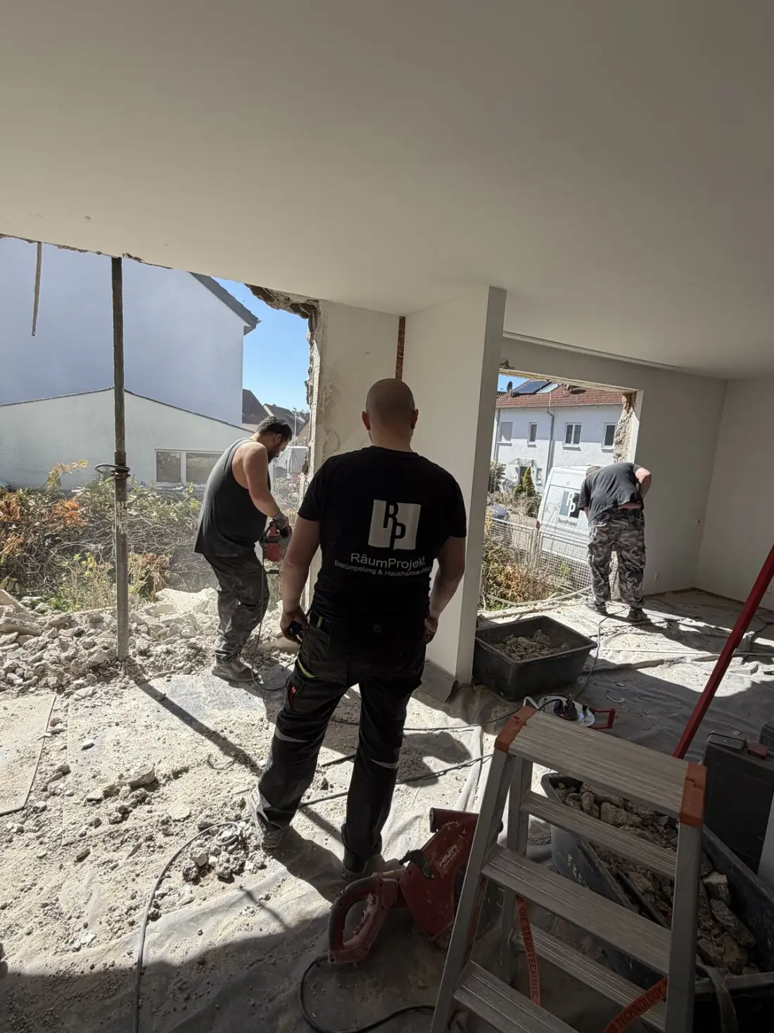 Mitarbeiter tragen Hausrat aus einer Wohnungsauflösung zum Firmenfahrzeug